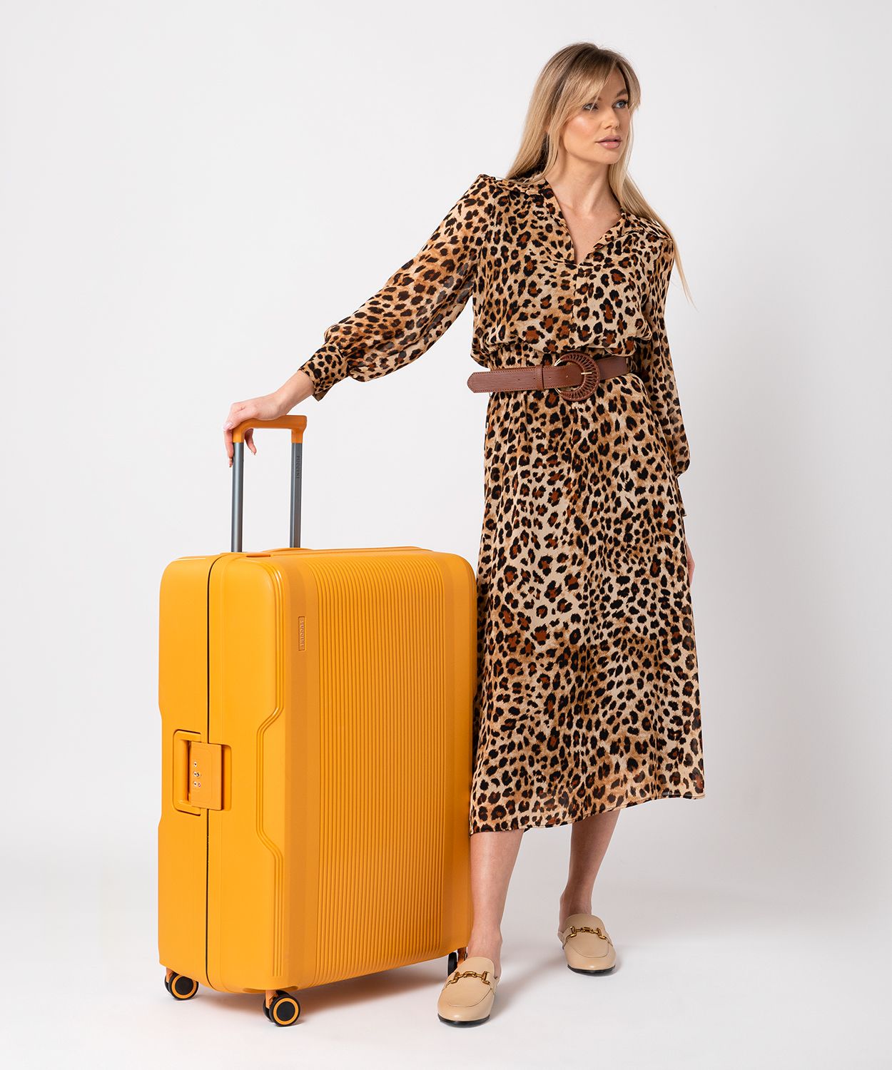 Велика жовта валіза закрита на пряжки