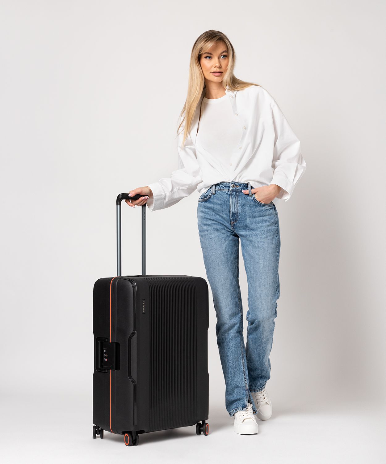 Середня чорна валіза ручної поклажі закрита на пряжки