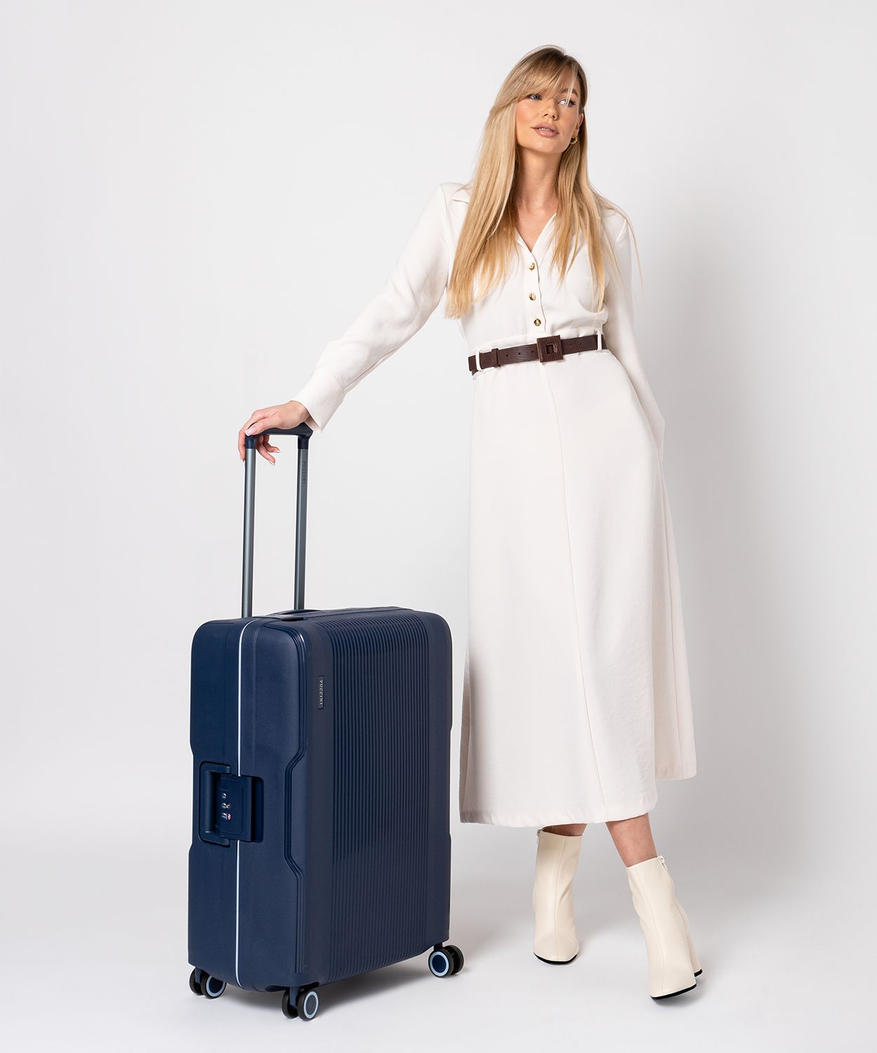 Темно-синя валіза ручної поклажі закрита на пряжки