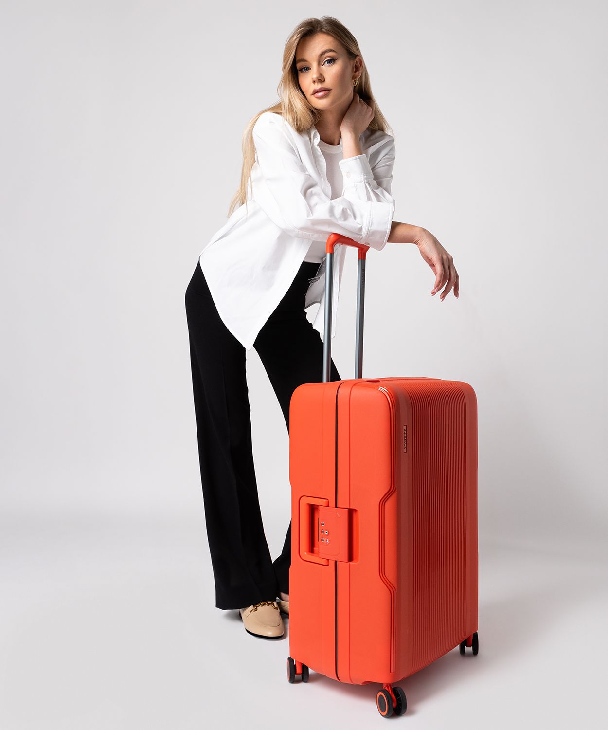 Середня помаранчева валіза ручної поклажі закрита на пряжки